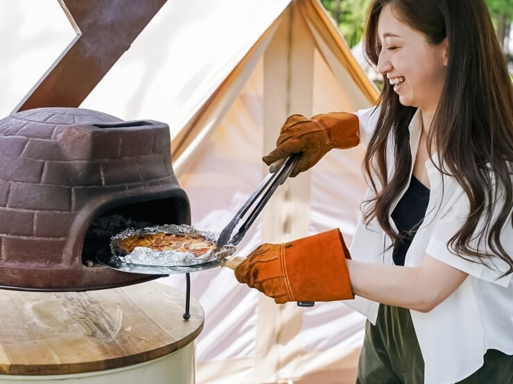 ピザ焼き体験を女性が楽しむ様子